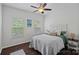 Bright and airy bedroom with two windows, wood floors, a full bed with a white tufted headboard and comfortable bedding at 7049 Sedgebrook W Dr, Stanley, NC 28164