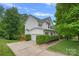 Charming two-story home with a two car garage, green landscaping, and a rear deck on a sunny day at 7049 Sedgebrook W Dr, Stanley, NC 28164