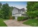 Charming home with white siding, black shutters, a well-manicured lawn, and mature trees at 7049 Sedgebrook W Dr, Stanley, NC 28164