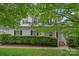 Two-story home featuring a manicured lawn, a front porch, a green hedge and a red door at 7049 Sedgebrook W Dr, Stanley, NC 28164