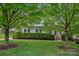 Charming two-story home with a manicured front yard, green hedge and tree-lined street at 7049 Sedgebrook W Dr, Stanley, NC 28164