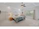Bright main bedroom with a tray ceiling, neutral decor, and a comfortable king-size bed, complemented by a ceiling fan at 7049 Sedgebrook W Dr, Stanley, NC 28164