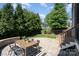 Private backyard featuring a stone patio, outdoor dining set, and mature trees at 710 Morgan Park Dr, Charlotte, NC 28204