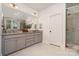 Bright bathroom featuring double sink vanity with gray cabinets, granite countertops, and tiled shower at 710 Morgan Park Dr, Charlotte, NC 28204