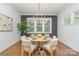 Bright dining room featuring a round table, chandelier, and large windows showcasing the outdoor greenery at 710 Morgan Park Dr, Charlotte, NC 28204