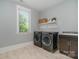 Functional laundry room with side by side machines, window, folding shelf, and sink at 710 Morgan Park Dr, Charlotte, NC 28204