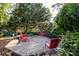Inviting backyard deck with red chairs, a bench and a beautiful tree at 714 Larkhall Ln, Charlotte, NC 28211