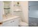 Well-lit bathroom with a toilet, a vanity and glass shelving above at 714 Larkhall Ln, Charlotte, NC 28211