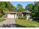 Mid-century modern home with a well manicured lawn and a two-car garage at 714 Larkhall Ln, Charlotte, NC 28211