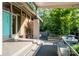 View of the front porch with a turquoise door, brick walls, and a seating area surrounded by lush greenery at 714 Larkhall Ln, Charlotte, NC 28211