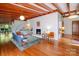 Spacious living room with exposed beam ceiling, hardwood floors, fireplace, and stylish contemporary furniture at 714 Larkhall Ln, Charlotte, NC 28211