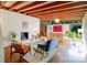 Bright living room with wood beam ceiling, fireplace, hardwood floors, and modern décor overlooking the backyard at 714 Larkhall Ln, Charlotte, NC 28211