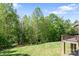 Lush green backyard featuring a neatly manicured lawn and mature trees, complemented by a deck at 730 Oak Ridge Farms Cir # 14, Newton, NC 28658