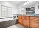 Bathroom featuring a soaking tub with grey tile backsplash and wood cabinets at 730 Oak Ridge Farms Cir # 14, Newton, NC 28658