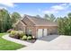 Side view of a brick home showcasing a two-car garage and well-kept landscaping under a clear sky at 730 Oak Ridge Farms Cir # 14, Newton, NC 28658