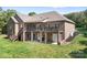 Rear exterior view showing a brick home with a deck, walk-out basement, and lush backyard at 730 Oak Ridge Farms Cir # 14, Newton, NC 28658