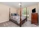 Comfortable bedroom with a four-poster bed, carpeted floors, and a large window providing natural light at 752 Pinebough Ln, Rock Hill, SC 29732