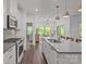 Modern kitchen with white cabinets, stainless steel appliances, a central island, and a view to dining area at 7620 Porrera St, Charlotte, NC 28214