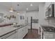Bright kitchen with white cabinets, stainless steel appliances, large island, and view to the living area at 7620 Porrera St, Charlotte, NC 28214