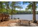 Charming lakefront picnic area with a grill, picnic table, and chairs overlooking the water at 7620 Porrera St, Charlotte, NC 28214