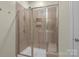 Modern shower stall features brown tile surround, glass door, and built-in seat at 7620 Porrera St, Charlotte, NC 28214