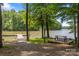 Peaceful waterfront area with a wooden dock, picnic table and mature shade trees at 7620 Porrera St, Charlotte, NC 28214