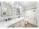 Bathroom with a double sink vanity, marble countertop, dark hardware, and tub/shower combo at 7718 Petrea Ln, Charlotte, NC 28227
