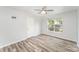 Bright bedroom features a ceiling fan, wood-look flooring, and a window with natural light at 7718 Petrea Ln, Charlotte, NC 28227