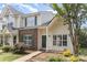 Charming townhome featuring a brick accent wall, green shutters, and lush landscaping at 7718 Petrea Ln, Charlotte, NC 28227