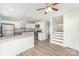 Bright kitchen boasts white cabinets, stainless steel appliances, and a breakfast bar that overlooks the staircase at 7718 Petrea Ln, Charlotte, NC 28227