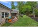 Charming backyard with a covered deck, a playset area, and lush landscaping, perfect for outdoor enjoyment at 7730 Burning Ridge Dr, Stanley, NC 28164
