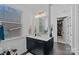 Well-lit bathroom with a black vanity, light countertop, brushed gold hardware, and walk-in closet at 7730 Burning Ridge Dr, Stanley, NC 28164