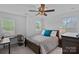 Cozy bedroom features a dark wood bed frame, and two windows that bring in natural light at 7730 Burning Ridge Dr, Stanley, NC 28164