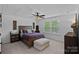 Comfortable bedroom featuring a dark wood bed frame, ceiling fan, and bright window at 7730 Burning Ridge Dr, Stanley, NC 28164