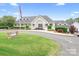 Elegant clubhouse exterior with manicured lawns, signage, and inviting entrance at 7730 Burning Ridge Dr, Stanley, NC 28164