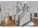 Inviting entryway featuring hardwood floors, white wainscoting, and a staircase with wood and white balusters at 7730 Burning Ridge Dr, Stanley, NC 28164