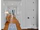Inviting hallway with hardwood floors, a decorative rug, and unique console table with accent lamp at 7730 Burning Ridge Dr, Stanley, NC 28164