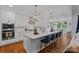Open kitchen featuring a large island with seating, modern appliances, and a seamless connection to the dining area at 7730 Burning Ridge Dr, Stanley, NC 28164