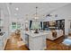 Kitchen featuring an island with a sink and stainless steel dishwasher, which is open to the living room and dining room at 7730 Burning Ridge Dr, Stanley, NC 28164