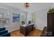 Bright office space with hardwood floors, three windows, and a large wooden desk with black leather chair at 7730 Burning Ridge Dr, Stanley, NC 28164