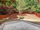 Lush backyard featuring a patio area, a wooden fence, vibrant landscaping, and mature trees at 7923 Shiny Meadow Ln, Charlotte, NC 28215