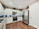 This well-lit kitchen boasts stainless steel appliances, white cabinetry, and gleaming hardwood floors at 7923 Shiny Meadow Ln, Charlotte, NC 28215