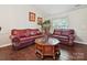 Living room view featuring hardwood flooring, sofas, art on wall, and natural light at 7923 Shiny Meadow Ln, Charlotte, NC 28215