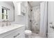 Bright bathroom with marble shower, white cabinets, sink, toilet and modern fixtures at 808 Sharon Dr, Waxhaw, NC 28173