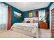Bright bedroom featuring teal walls, a large window, a white bed and wooden drawers at 808 Sharon Dr, Waxhaw, NC 28173