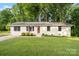 Charming single-story home with a well-manicured lawn and a vibrant red front door at 808 Sharon Dr, Waxhaw, NC 28173