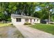 Beautifully landscaped single-story home with a white facade and a long, paved driveway at 808 Sharon Dr, Waxhaw, NC 28173