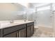 Bright bathroom featuring a double sink vanity, large mirror, and shower-tub combo at 9109 Loch Glen Way, Charlotte, NC 28278