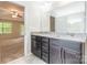 Bathroom with a double sink vanity featuring granite countertops and dark wood cabinets at 9109 Loch Glen Way, Charlotte, NC 28278