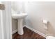 Neat half bathroom with a pedestal sink and hardwood floors at 9109 Loch Glen Way, Charlotte, NC 28278